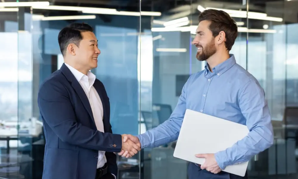 Managed service provider representative shaking a small business owner’s hand.